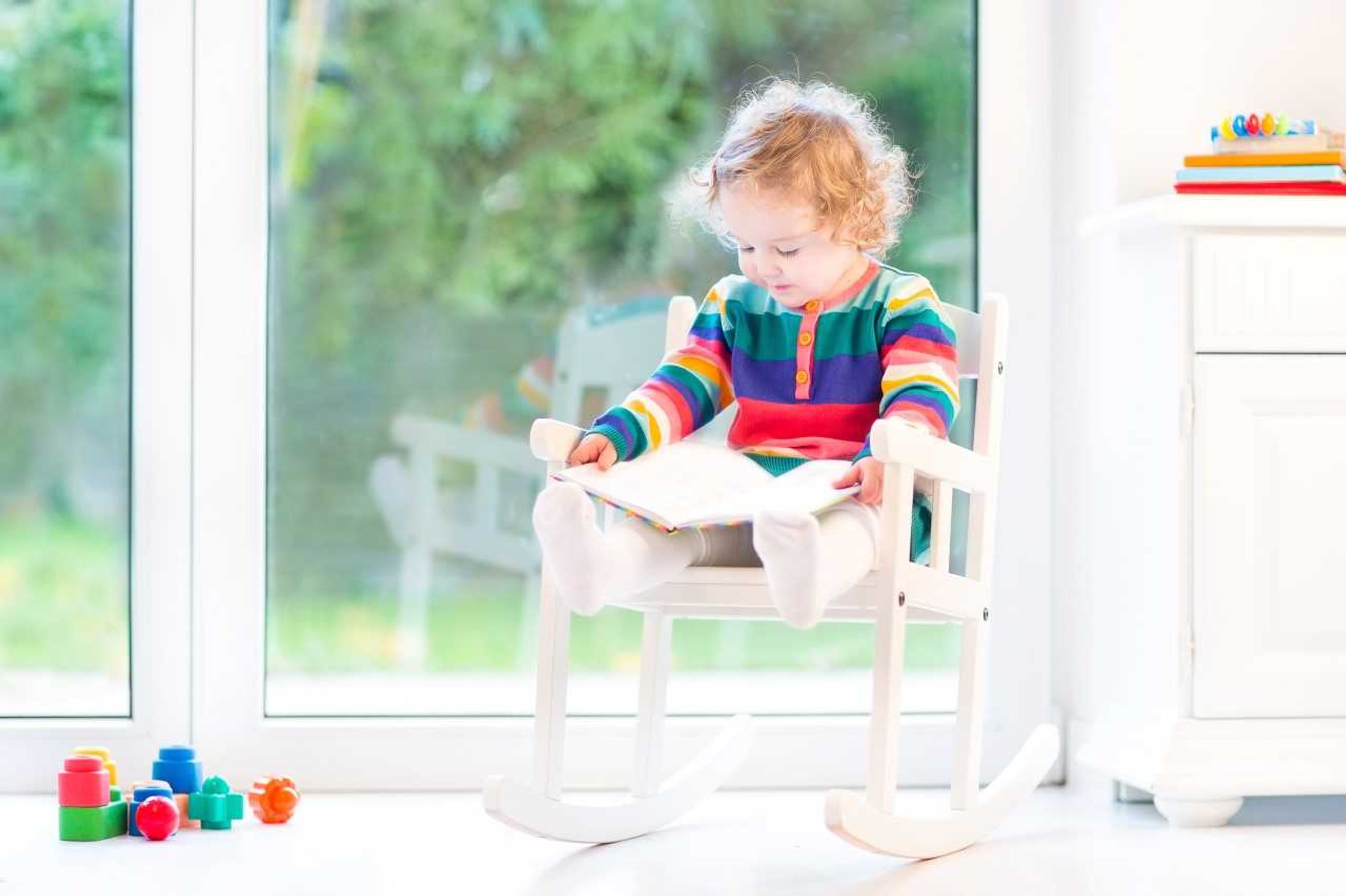 child reading a book on a rocking chair.jpg